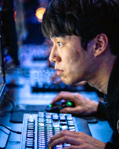 明星选手'Faker'在比赛中神情专注操作键盘鼠标的侧脸特写